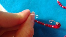 memory wire hoop with beads on it and small perpendicular loops at either end